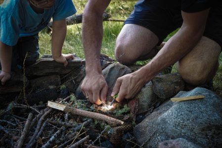 cropped-image-father-boy-burning-firewood-min